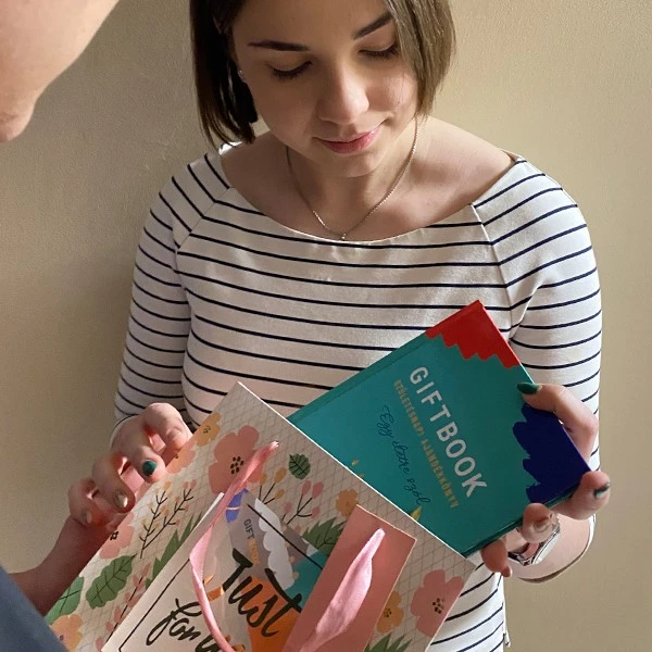 Egy hölgy ajándékba kapja a Giftbook ajándékkönyvet.